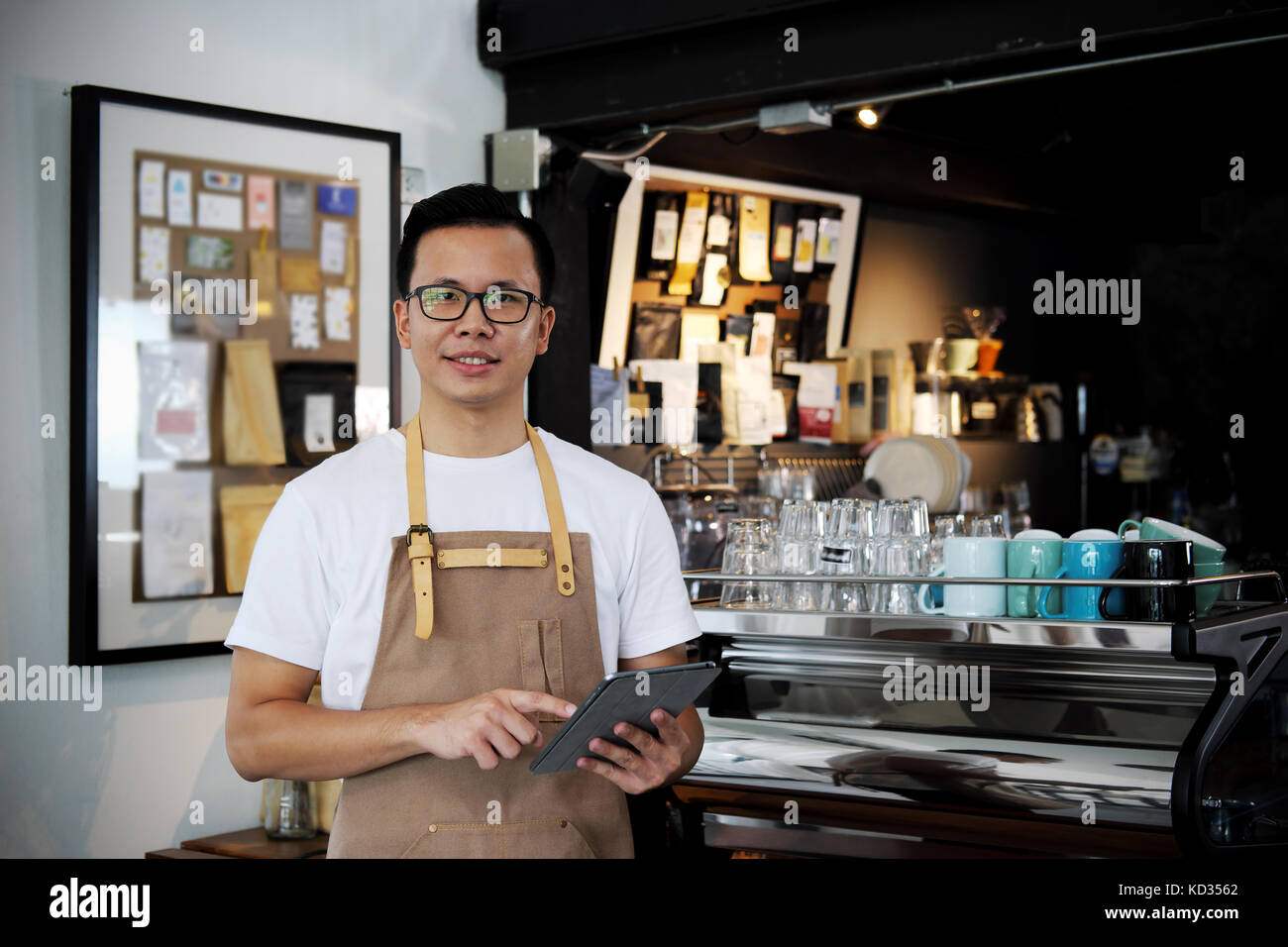 Portrait of smiling asian barista holding digital tablet in coffee shop. café restaurant service, propriétaire de petite entreprise, de l'alimentation et boissons l'indu Banque D'Images