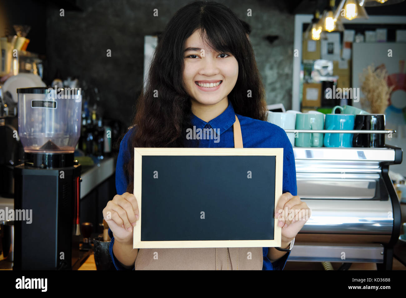 Portrait of smiling asian barista holding blank chalkboard menu de café. café restaurant service, propriétaire de petite entreprise, l'industrie alimentaire et des boissons Banque D'Images