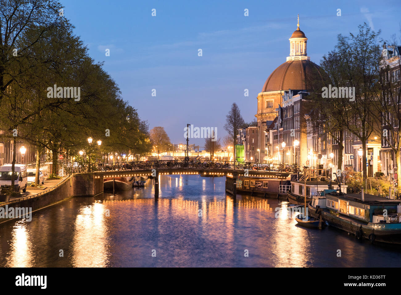 Le canal Singel à Amsterdam, de nuit, avec l'Église luthérienne ronde sur la droite Banque D'Images