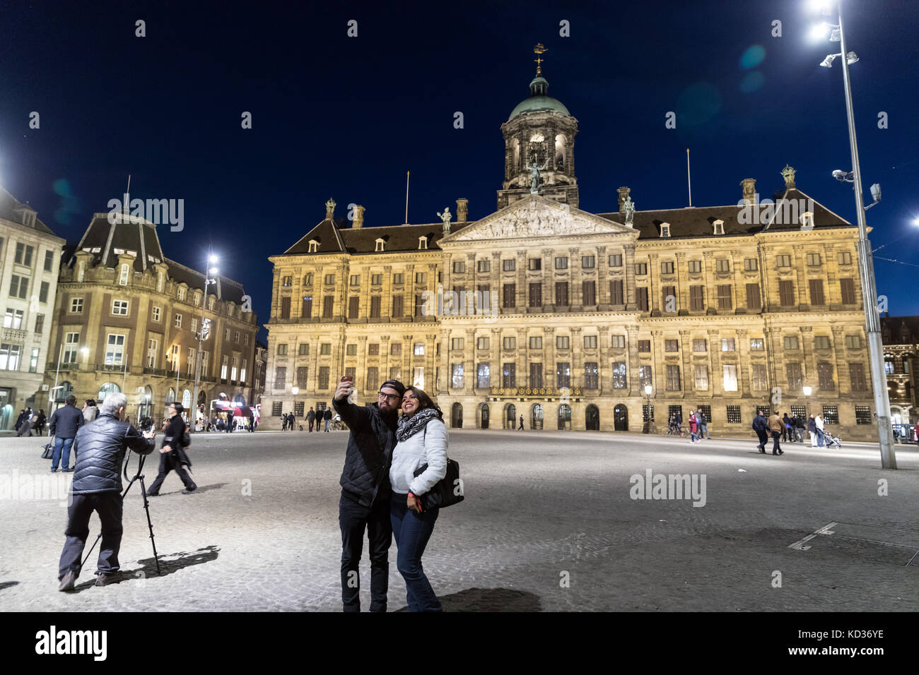Un couple prendre un barrage en selfies Squre, Amsterdam, avec le Palais Royal à l'arrière-plan Banque D'Images