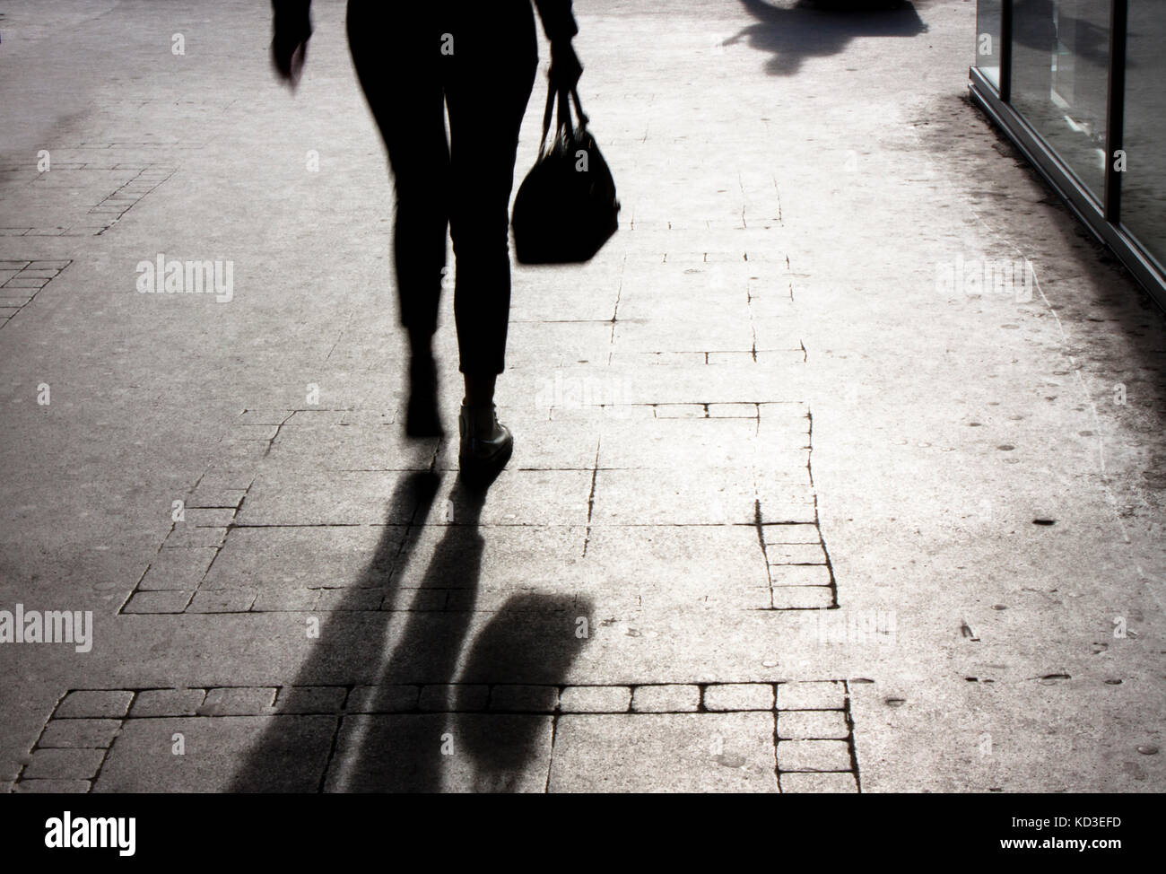 Jeune femme floue avec un sac à main de marcher seul sur la rue de la ville, en noir et blanc Banque D'Images