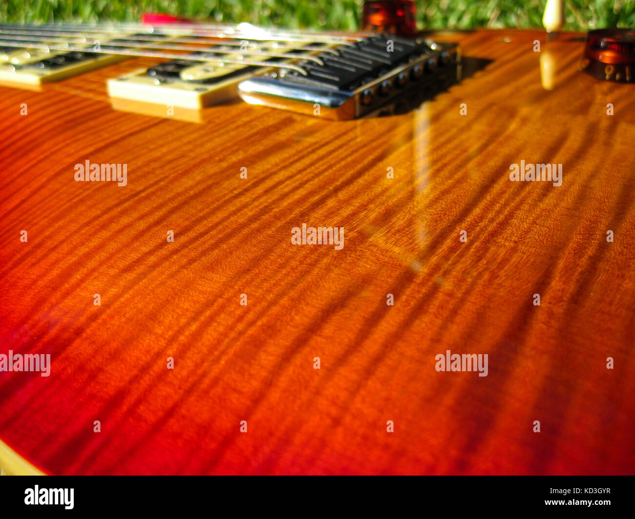 L'érable flamme prs cherry burst guitare brillants dans le soleil de l'après-midi. Banque D'Images