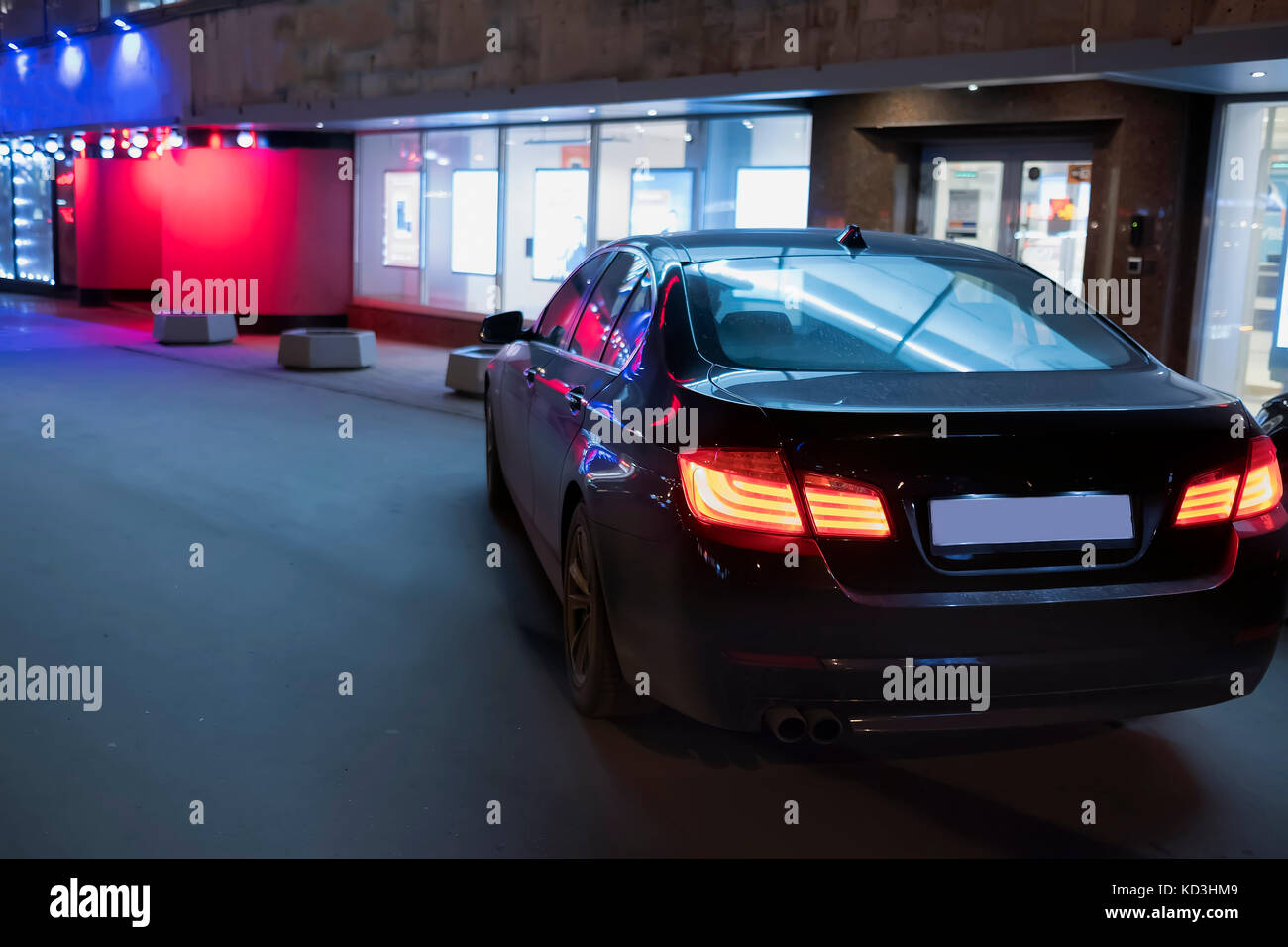 La voiture, à côté du magasin, à la nuit avec les feux brûlant Banque D'Images