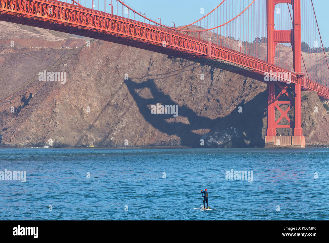 Un surfeur a été paddle dans la baie de San Francisco, sous le golden gate bridge, en Californie. Banque D'Images
