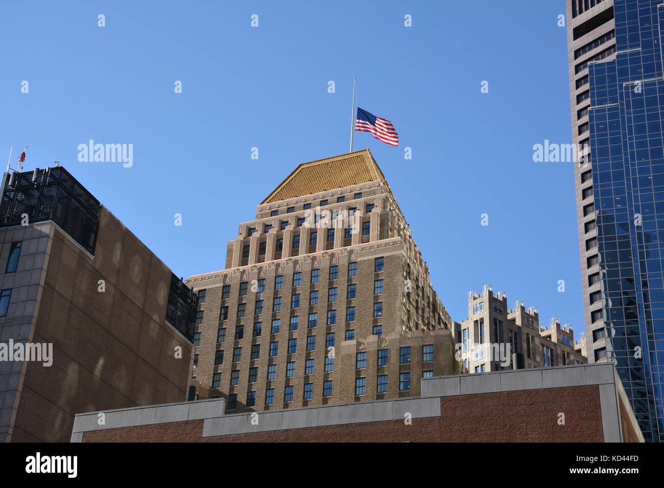 Les États-Unis d'un drapeau au sommet d'un gratte-ciel art déco sur un beau jour de fin d'été. Banque D'Images Les États-Unis d'un drapeau au sommet d'un gratte-ciel art déco sur un beau jour de fin d'été. Banque D'Images