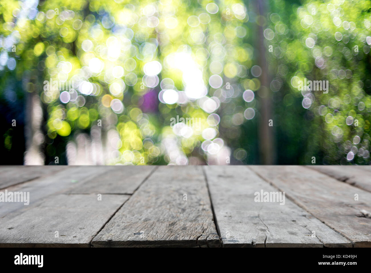 Table en bois en face de l'arrière-plan flou flou avec l'arbre de la feuille verte Banque D'Images