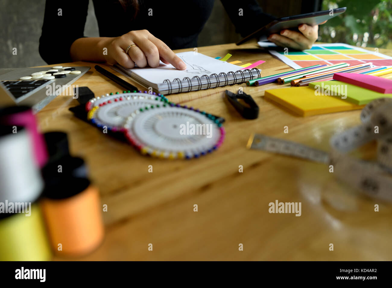Jeune créateur de mode de travail sur la table avec l'outil sur mesure Ordinateur et tablette Banque D'Images