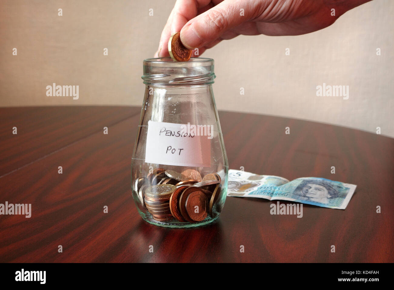 Ajouter de l'argent à la Pension Pot pot bocal en verre sur la table épargne-retraite la pauvreté financière des temps difficiles Banque D'Images