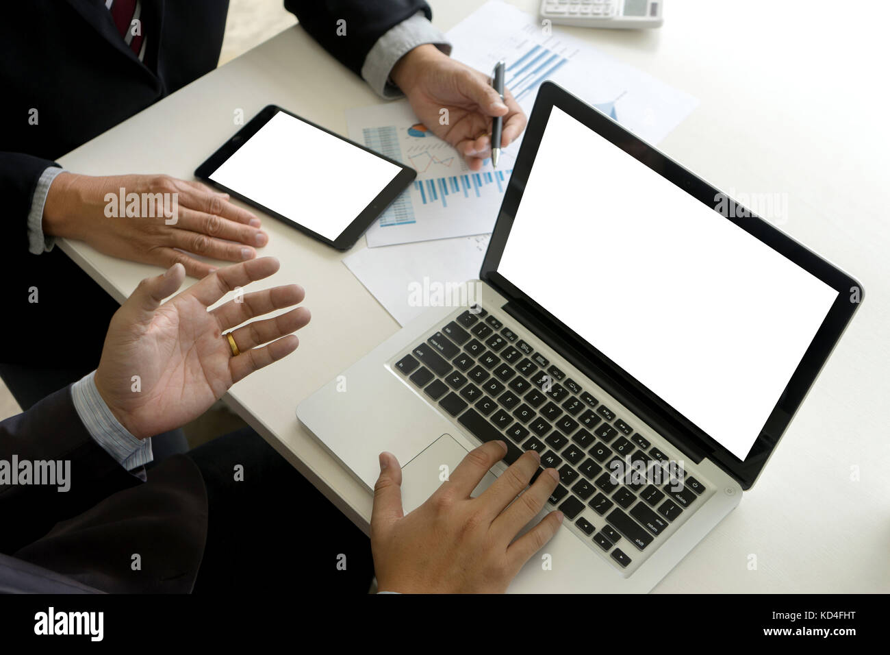 Deux man utilisent l'ordinateur et de l'analyse graphique papier sur table avec ordinateur et écran de tablette clipping path Banque D'Images