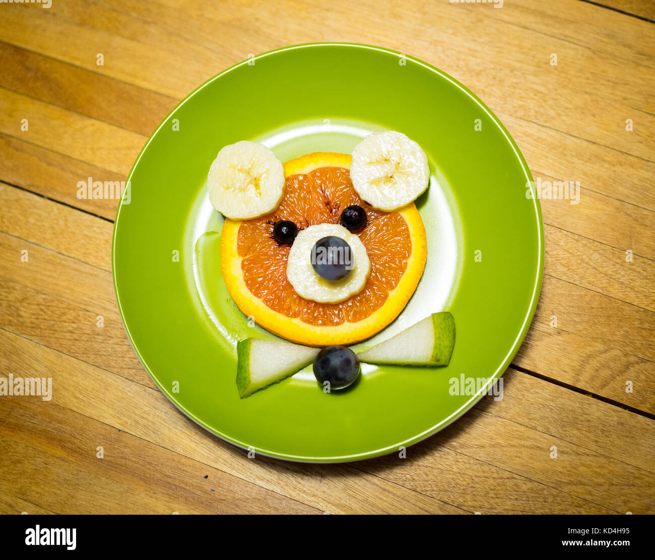 L'art de l'alimentation de l'ours pour les enfants. (Art) L'alimentation de l'ours de fruits. Faites de Orange, Banane, bleuets, raisins, et de poire. Banque D'Images