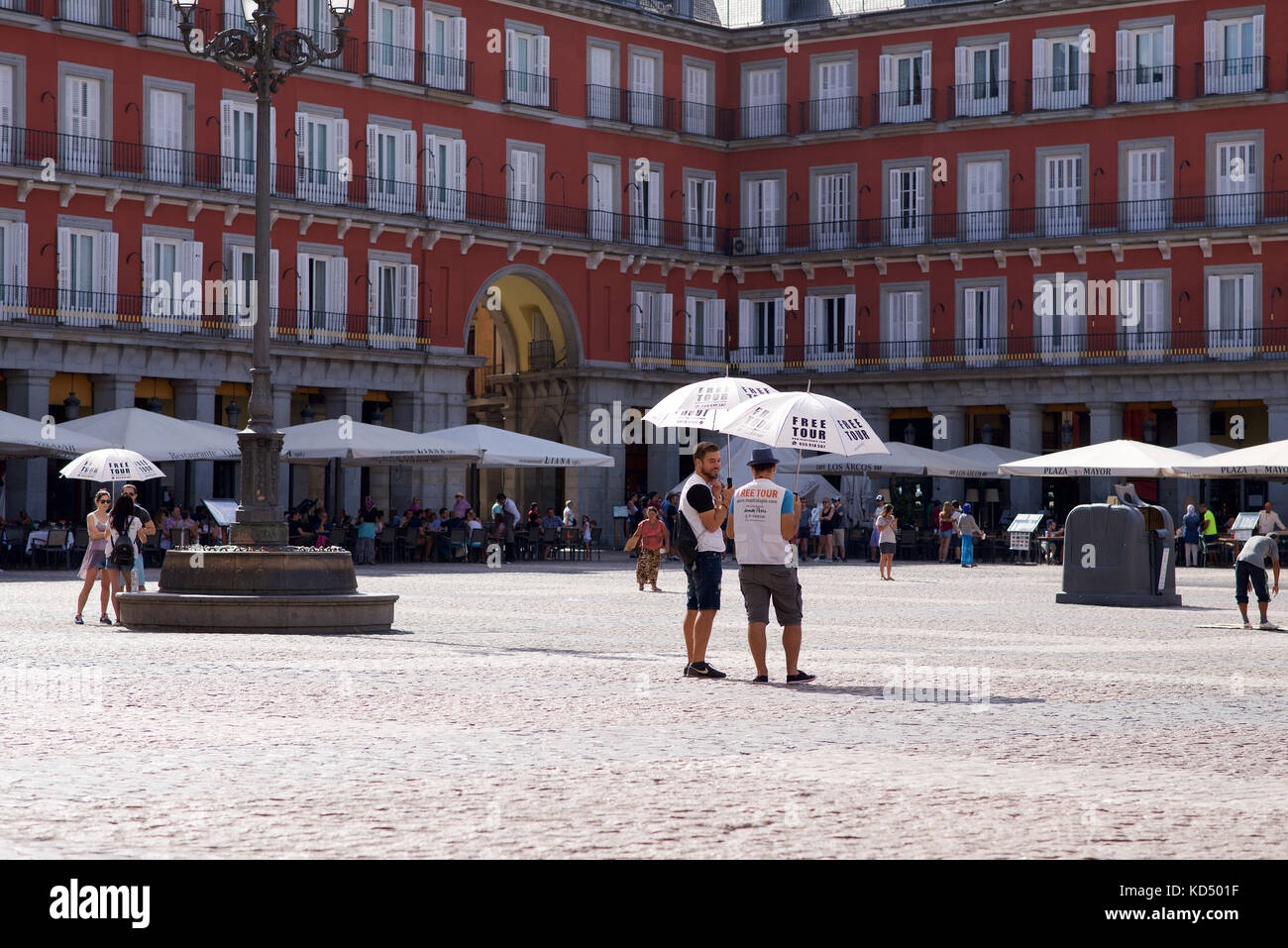 Guide touristique avec parasol pour l'ombre dans la plaza mayor, Madrid, Espagne Banque D'Images