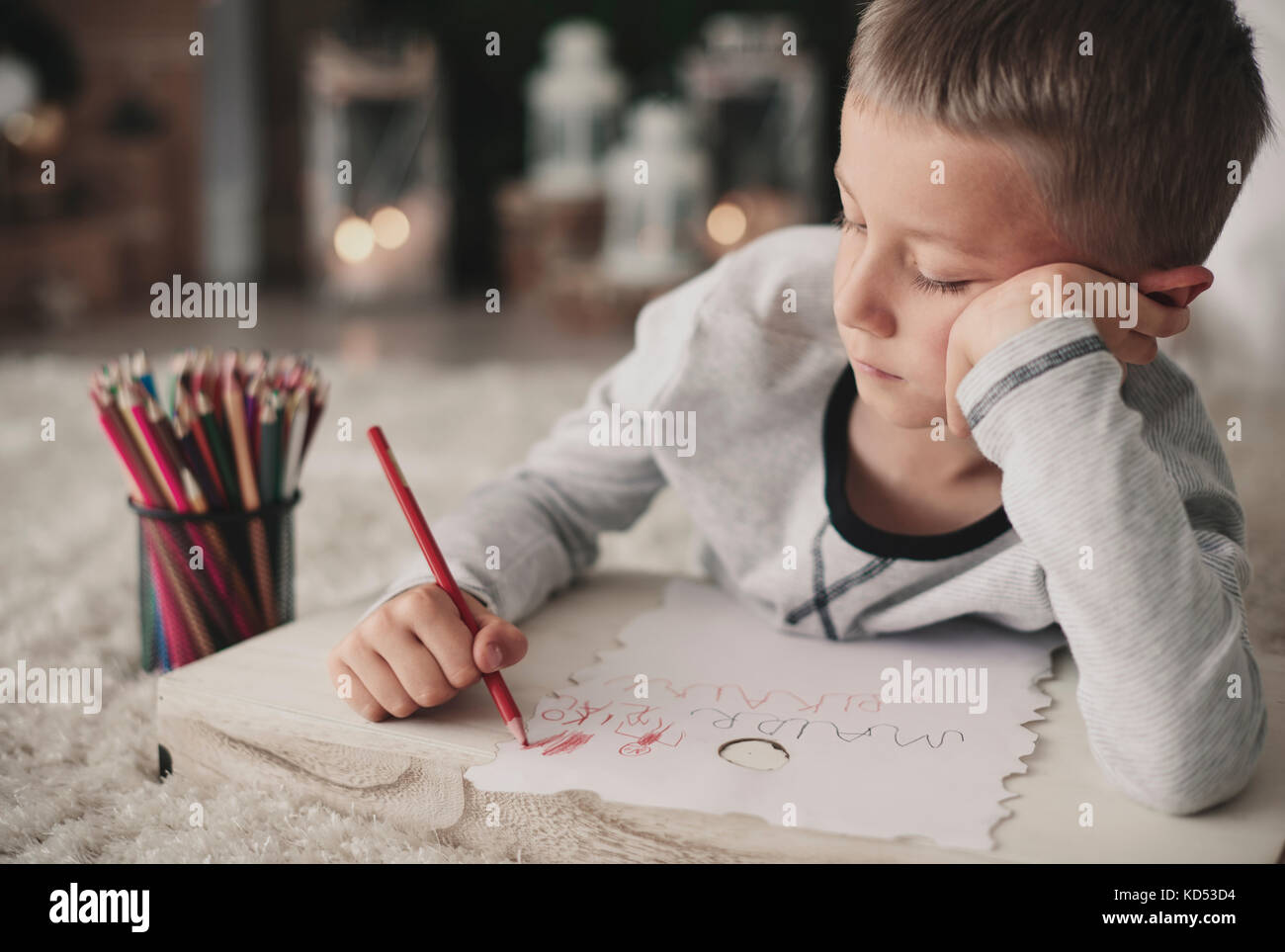 Un garçon ennuyé qui dessine sur le sol Banque D'Images