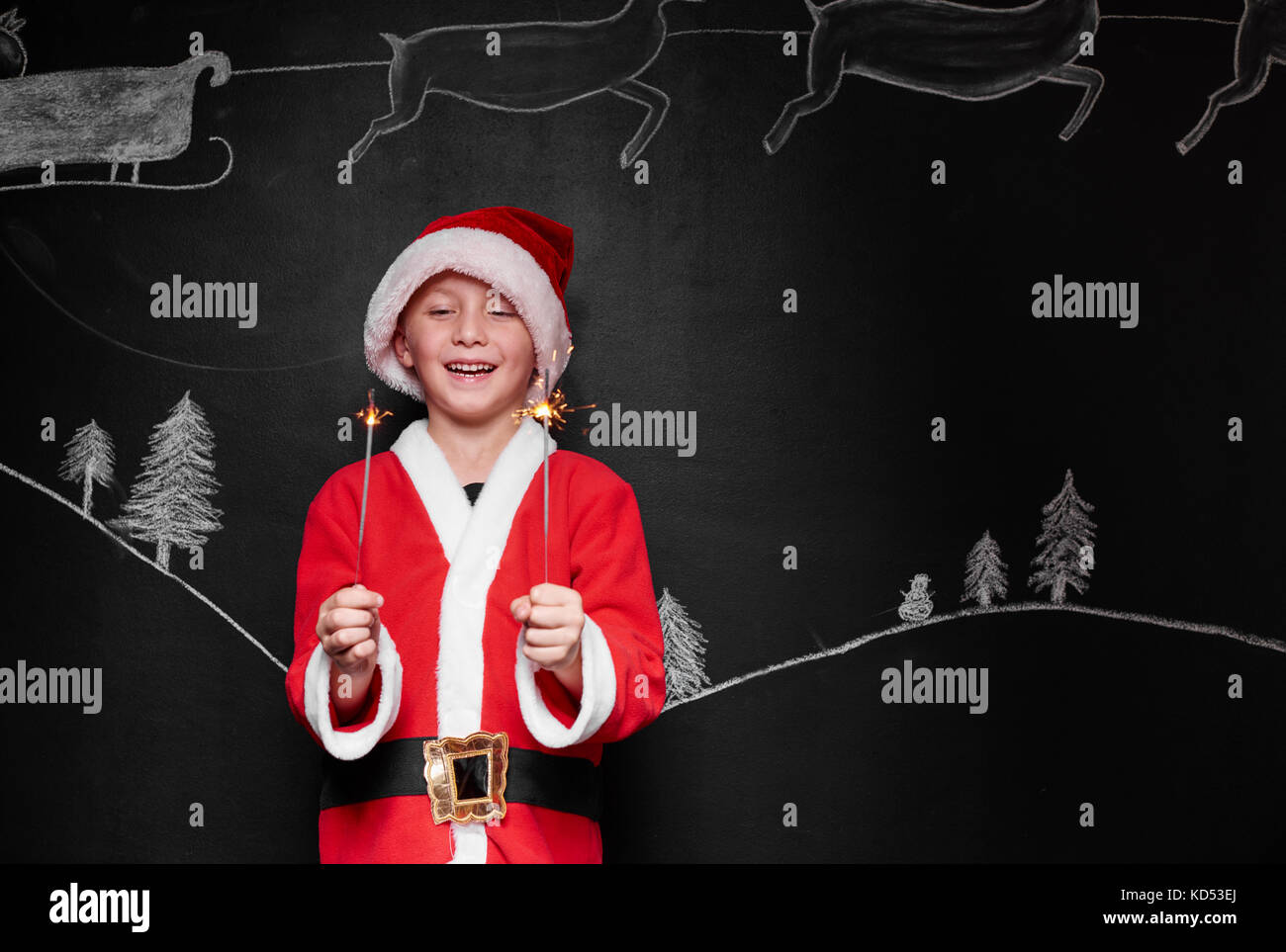 Enfant déguisé en père Noël, bénéficiant d''un sparkler Banque D'Images