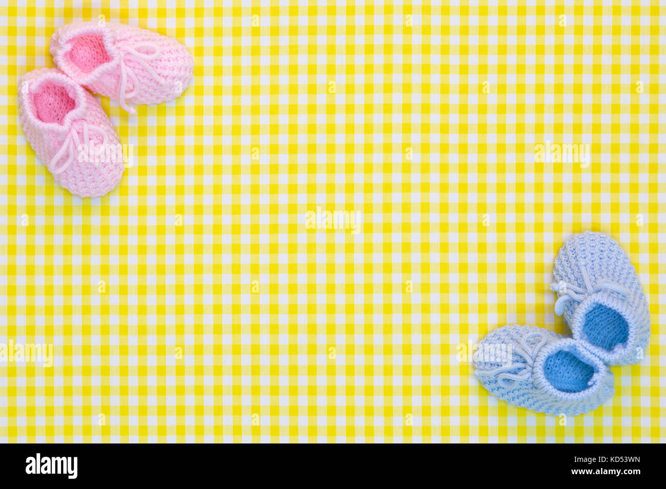 Kinitted chaussons pour bébé pour une fille et un garçon sur un fond vichy jaune. Banque D'Images