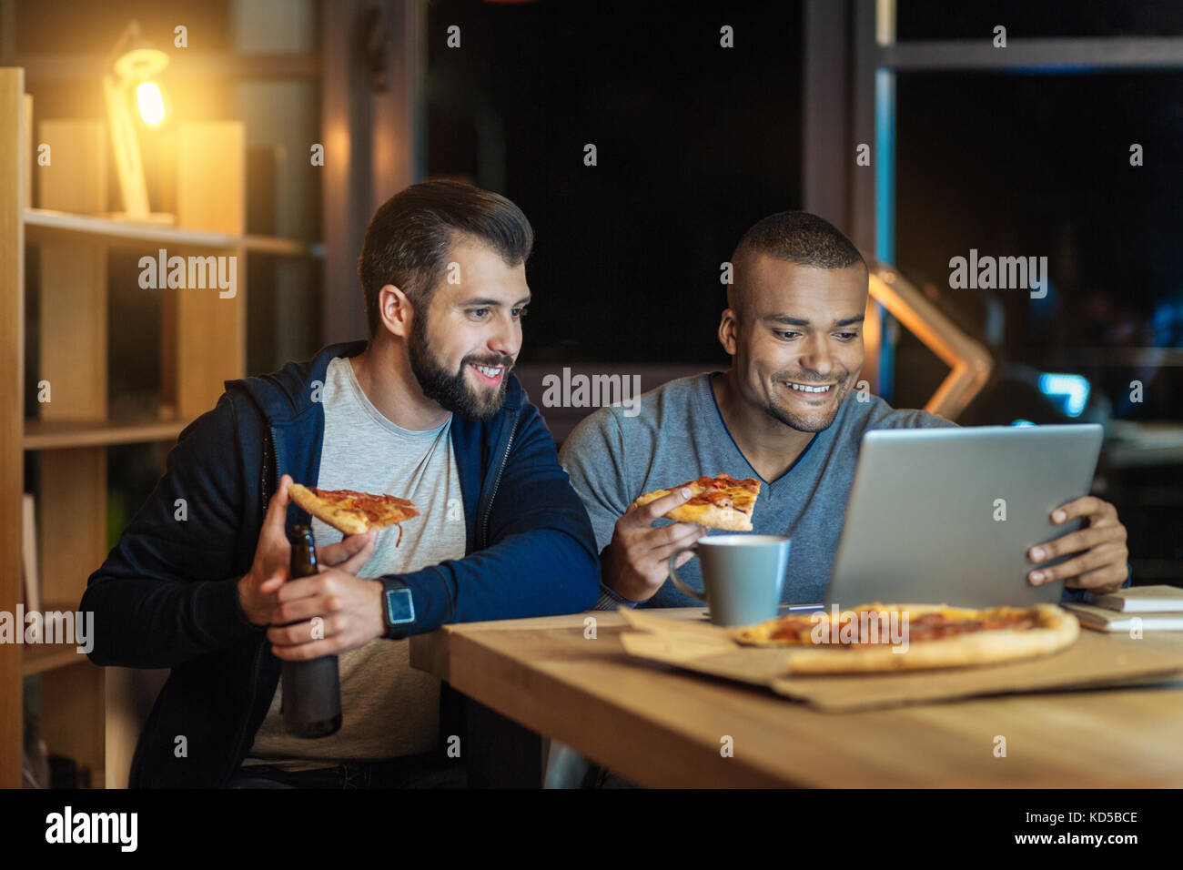 Les mâles détendue manger pizza savoureuse Banque D'Images
