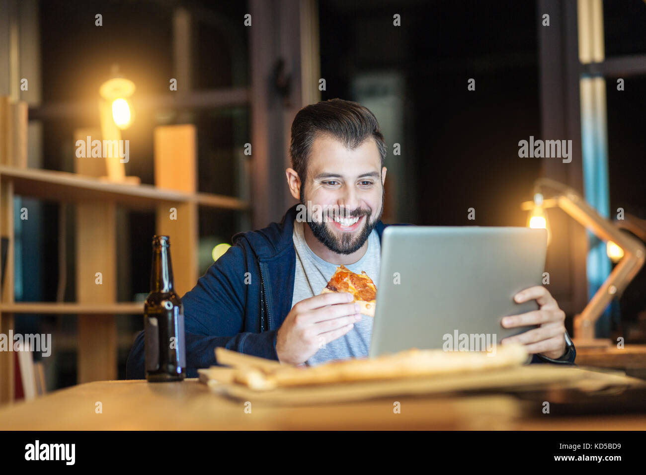 Handsome man smiling while eating Banque D'Images