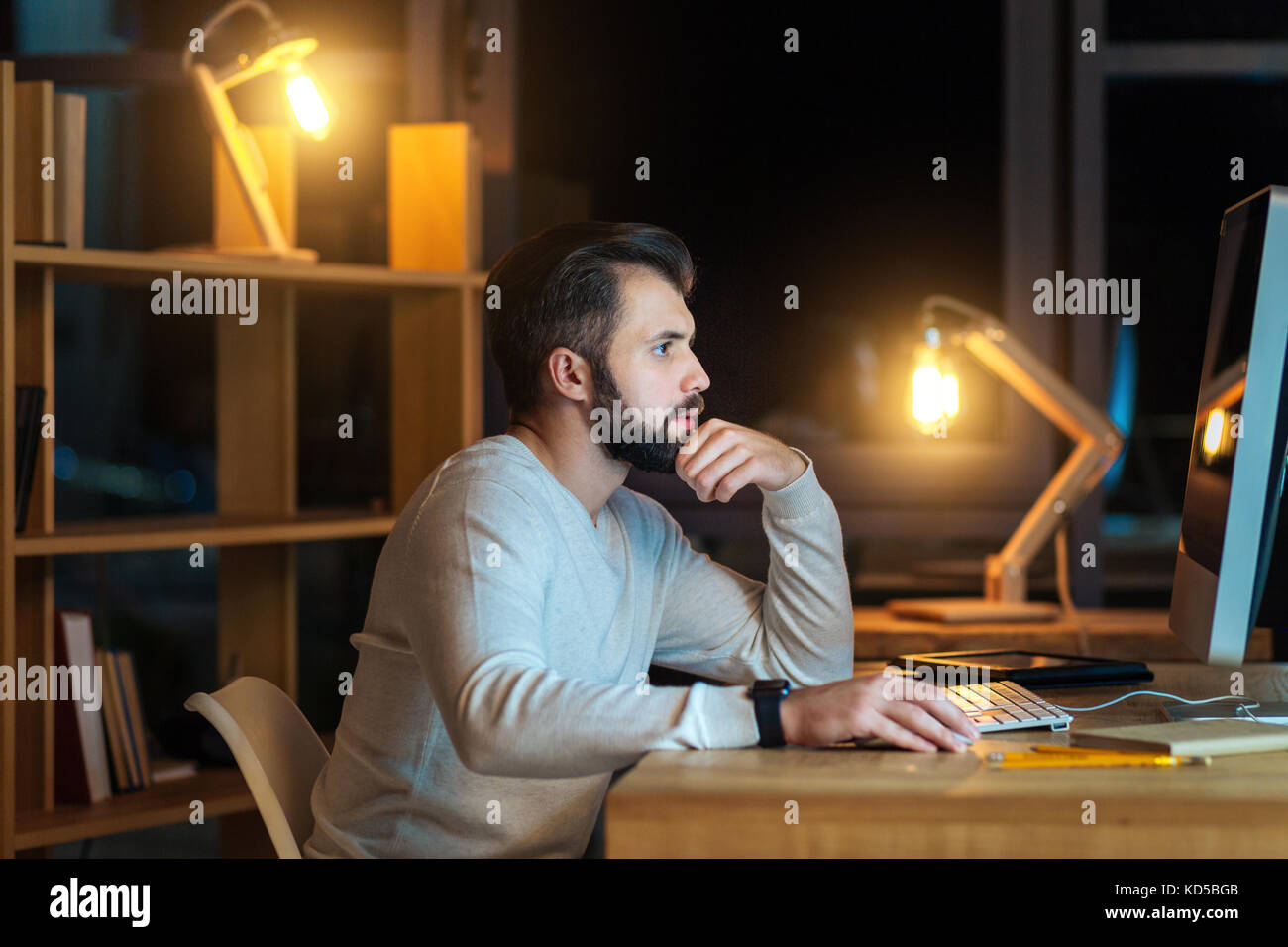 Photo du profil de concentré de mâle qui fini sa tâche Banque D'Images