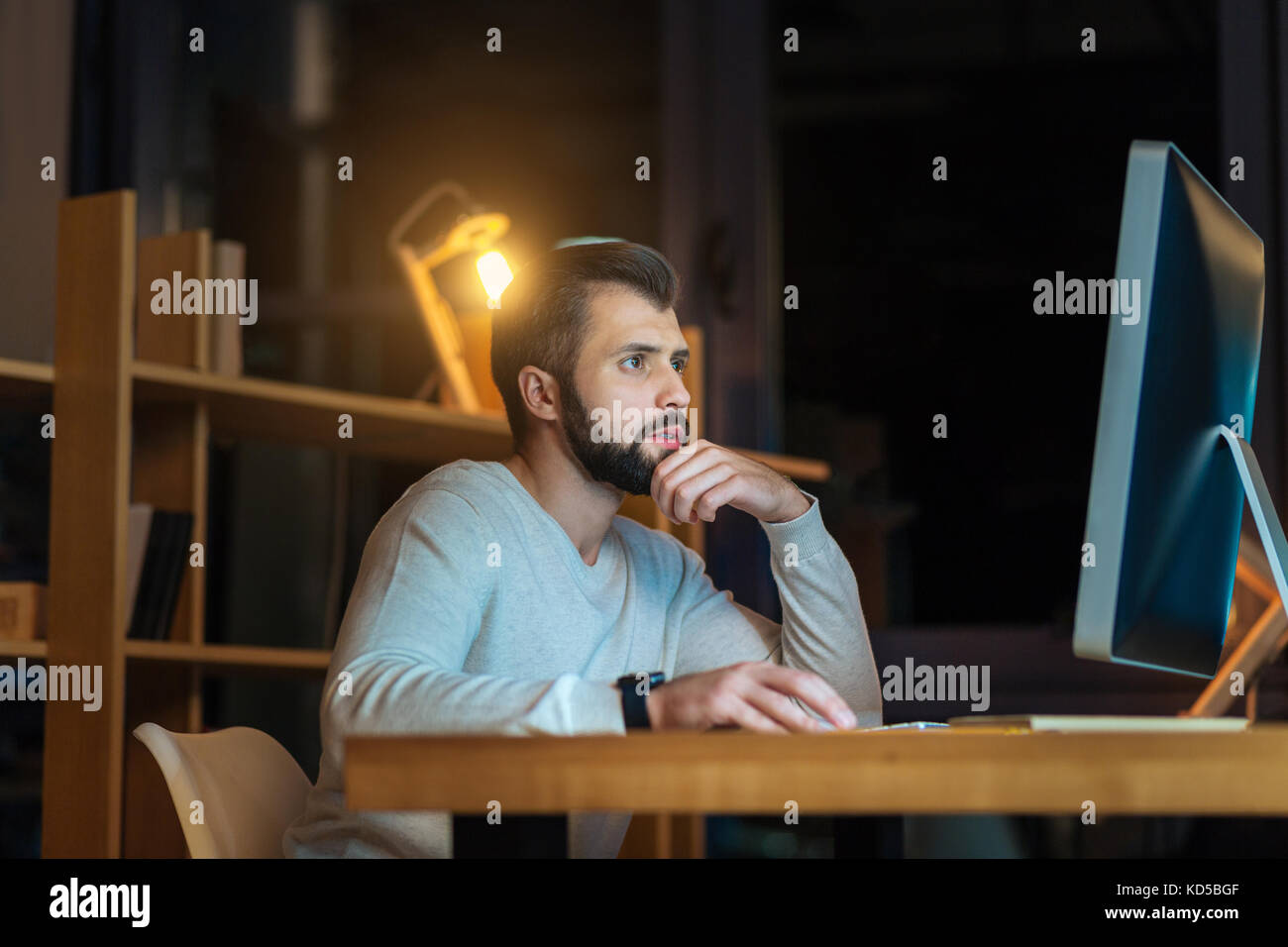 Programmeur barbus graves assis sur son lieu de travail Banque D'Images