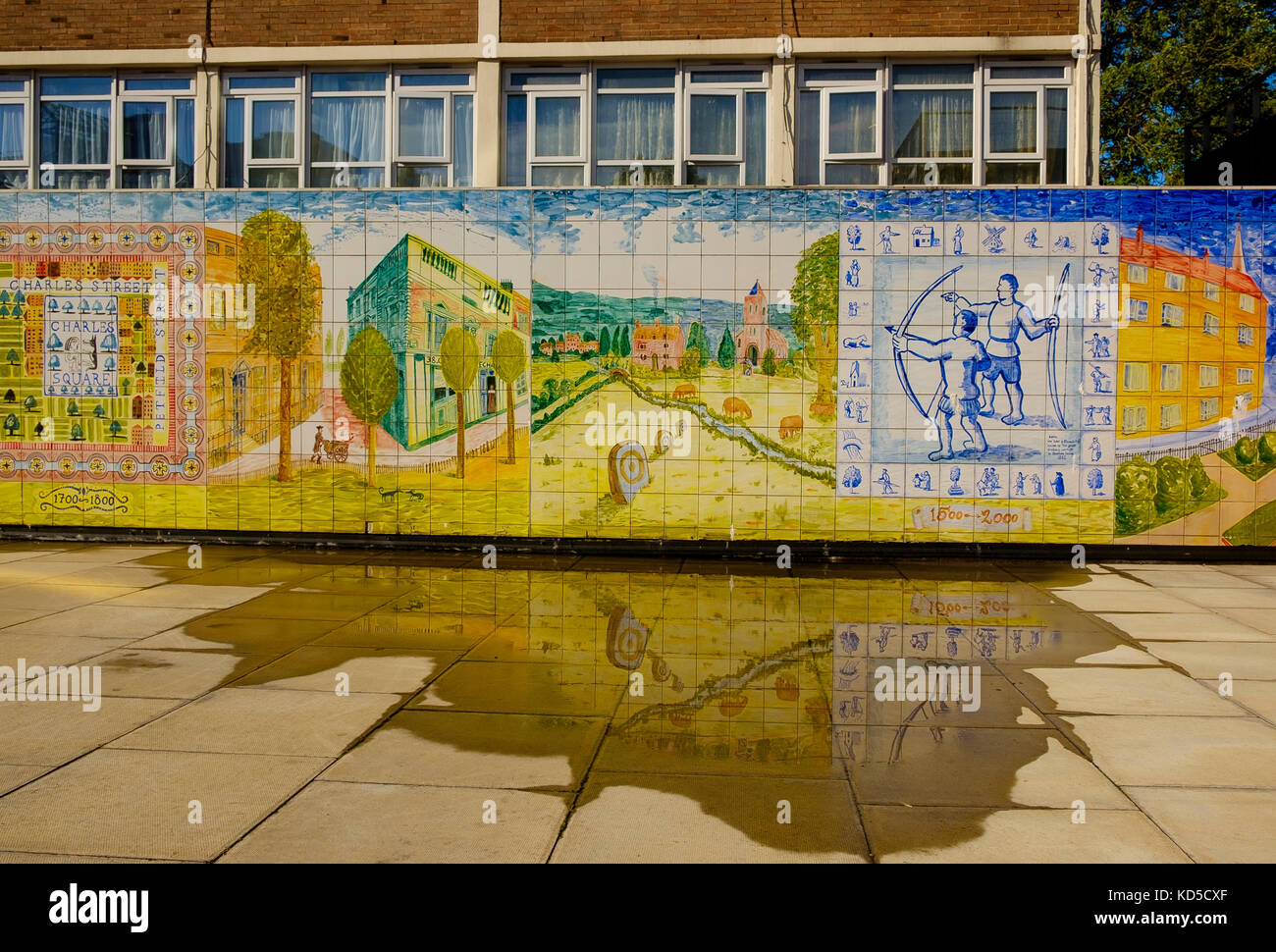 Le Council s'emboîte à Hoxton, Londres, au Royaume-Uni, avec une fresque artistique colorée de l'histoire de Charles Square reflétée dans une grande flaque d'eau de pluie Banque D'Images