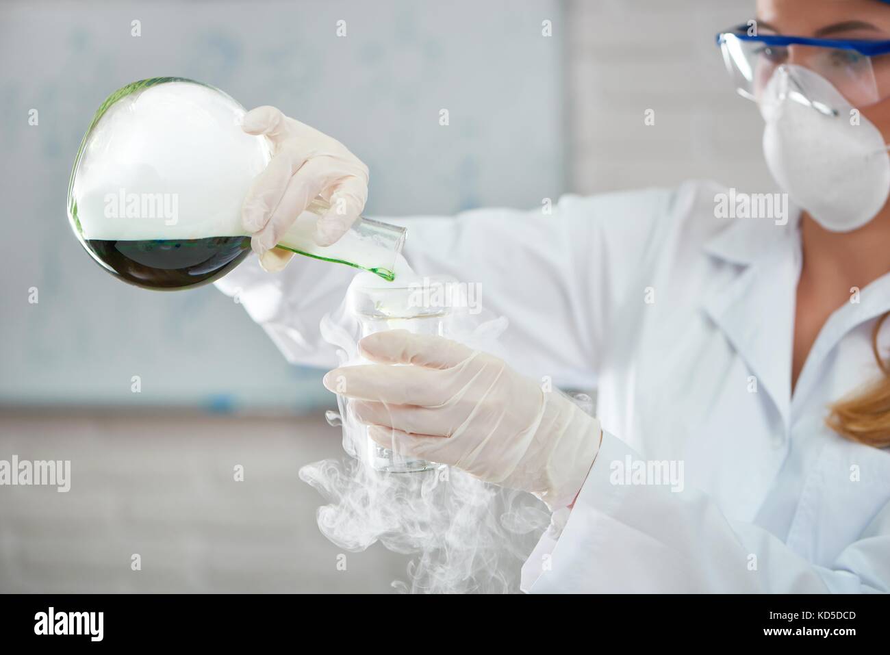 Cropped shot of a female chemist portant des lunettes et masque de tester les échantillons au laboratoire. Banque D'Images