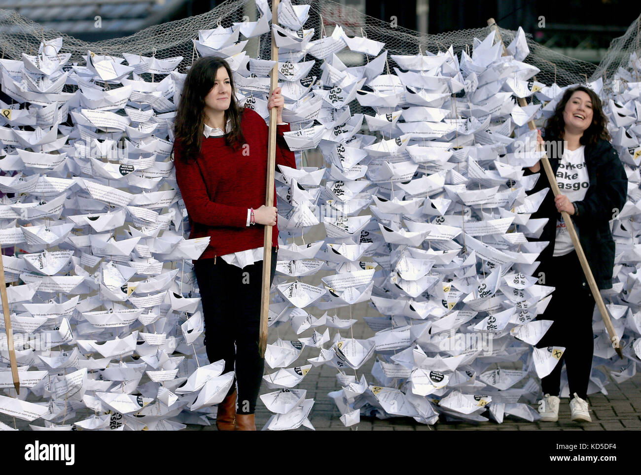 Hazel Nolan (à gauche) et Rhea Wolfson, membres du GMB en Écosse, se tiennent aux côtés de 2,000 bateaux en papier, fabriqués à partir de copies du manifeste du SNP, tandis que le syndicat lance un appel public au nom de 2,000 demandeurs de l'égalité salariale, exhortant le Conseil municipal de Glasgow à lancer les négociations Dès que possible, Lors de la conférence du Parti national écossais au SEC Centre de Glasgow. Banque D'Images