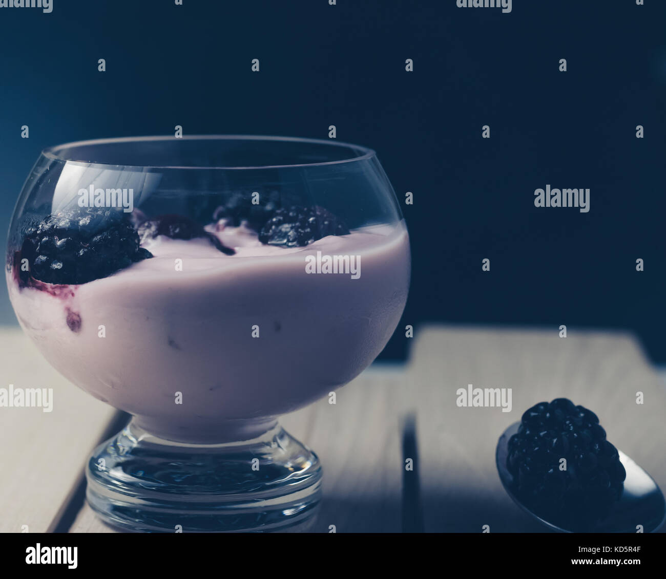 Le yogourt aux fruits avec des mûres sur une surface en bois, vue avant, arrière-plan foncé Banque D'Images