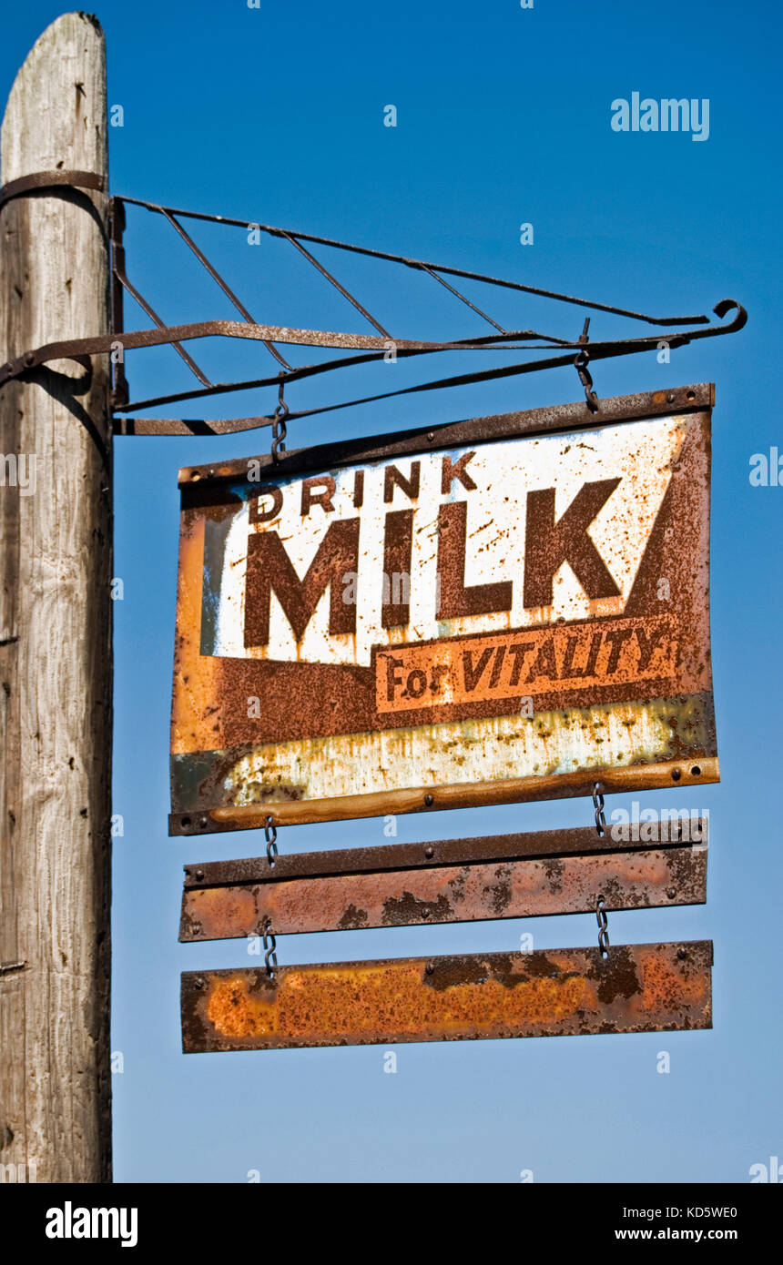 Lait rouillée rétro signe sur poster avec fond de ciel bleu Banque D'Images Lait rouillée rétro signe sur poster avec fond de ciel bleu Banque D'Images