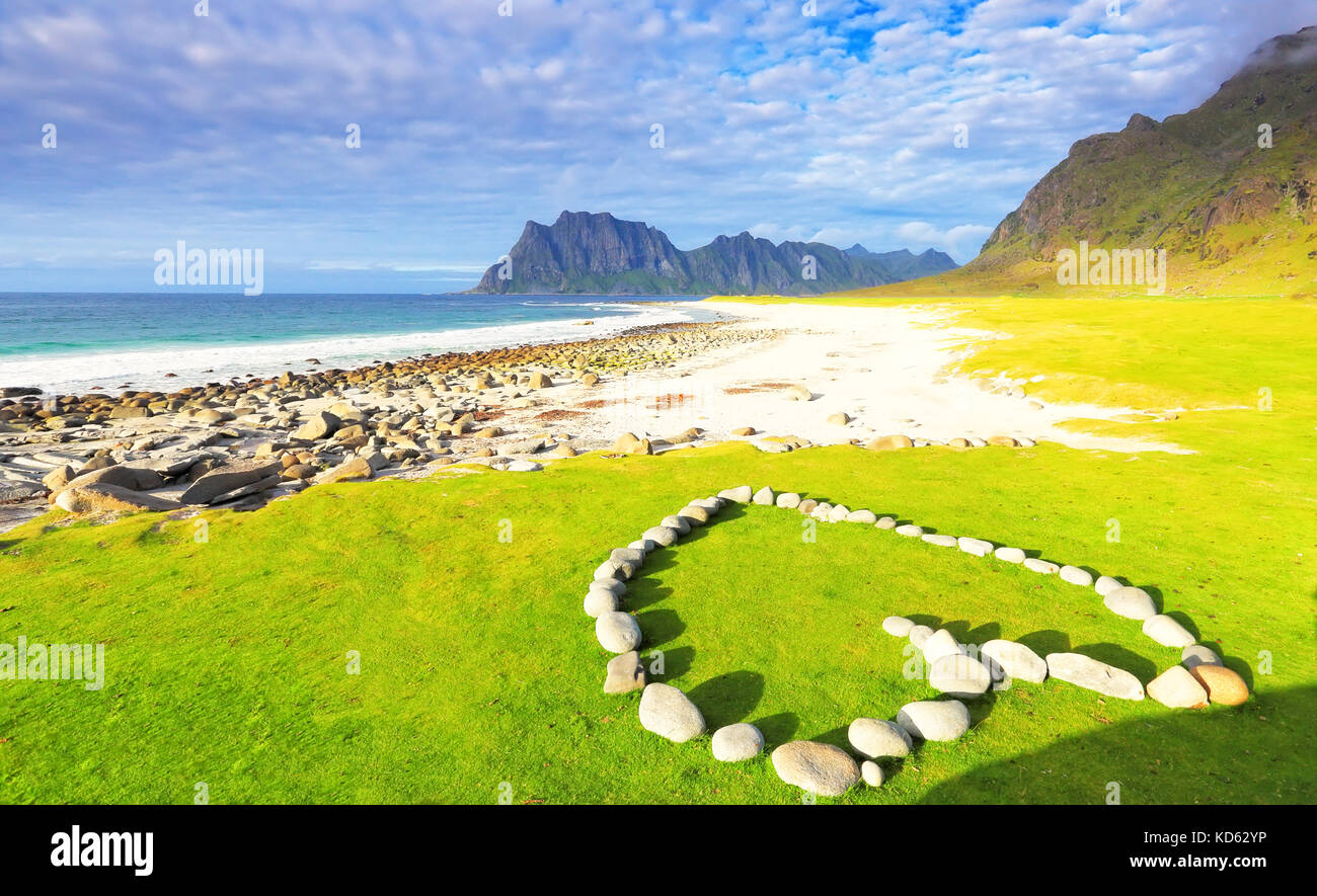 Plage romantique au coucher du soleil. pierres blanches en forme coeur de pose sur l'herbe verte. célèbre uttakleiv beach sur les îles Lofoten. Banque D'Images
