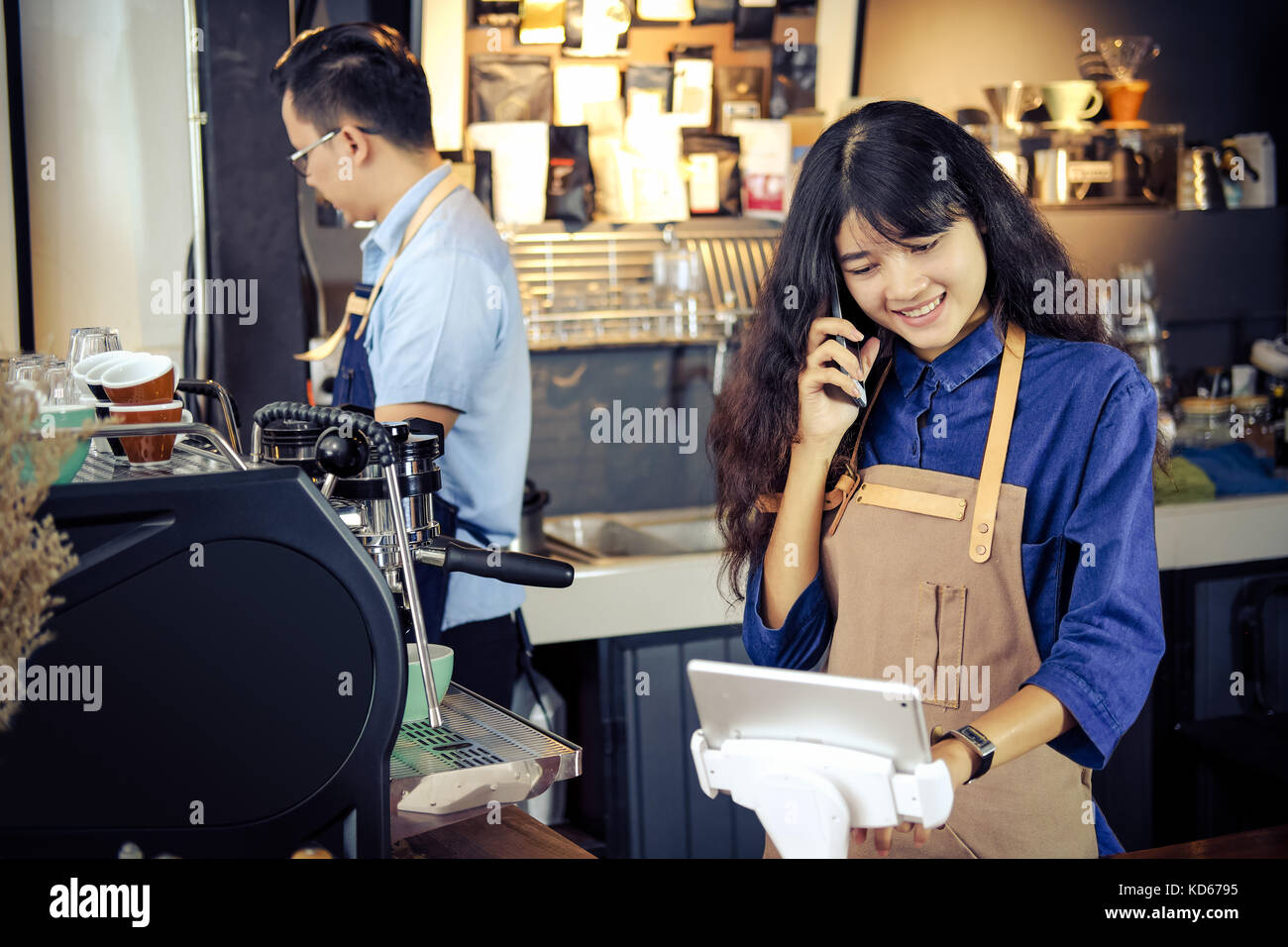 Barista asiatique parler commander par téléphone dans sa boutique. café restaurant service, propriétaire de petite entreprise, l'industrie alimentaire et des boissons concept. Banque D'Images