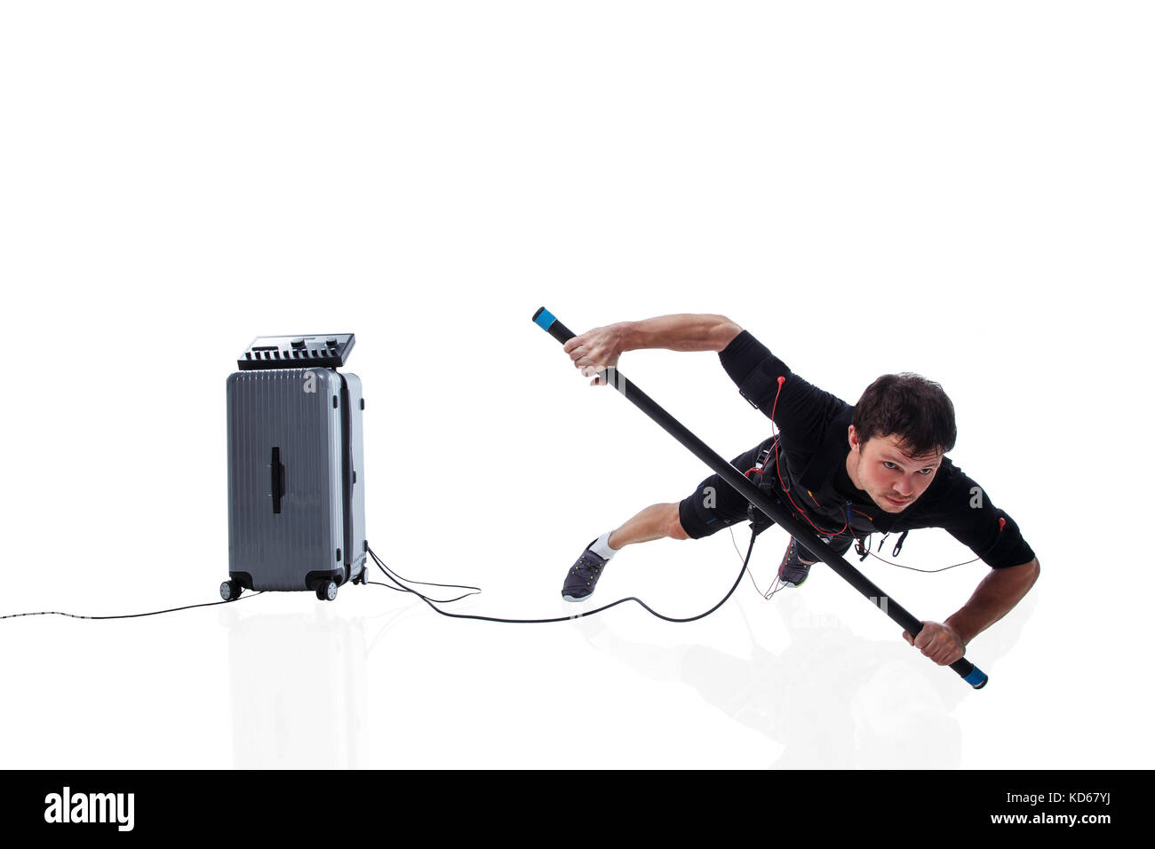 Athletic fitness homme en costume de stimulation musculaire électrique faisant une part plank avec body bar, studio isolé sur fond blanc Banque D'Images