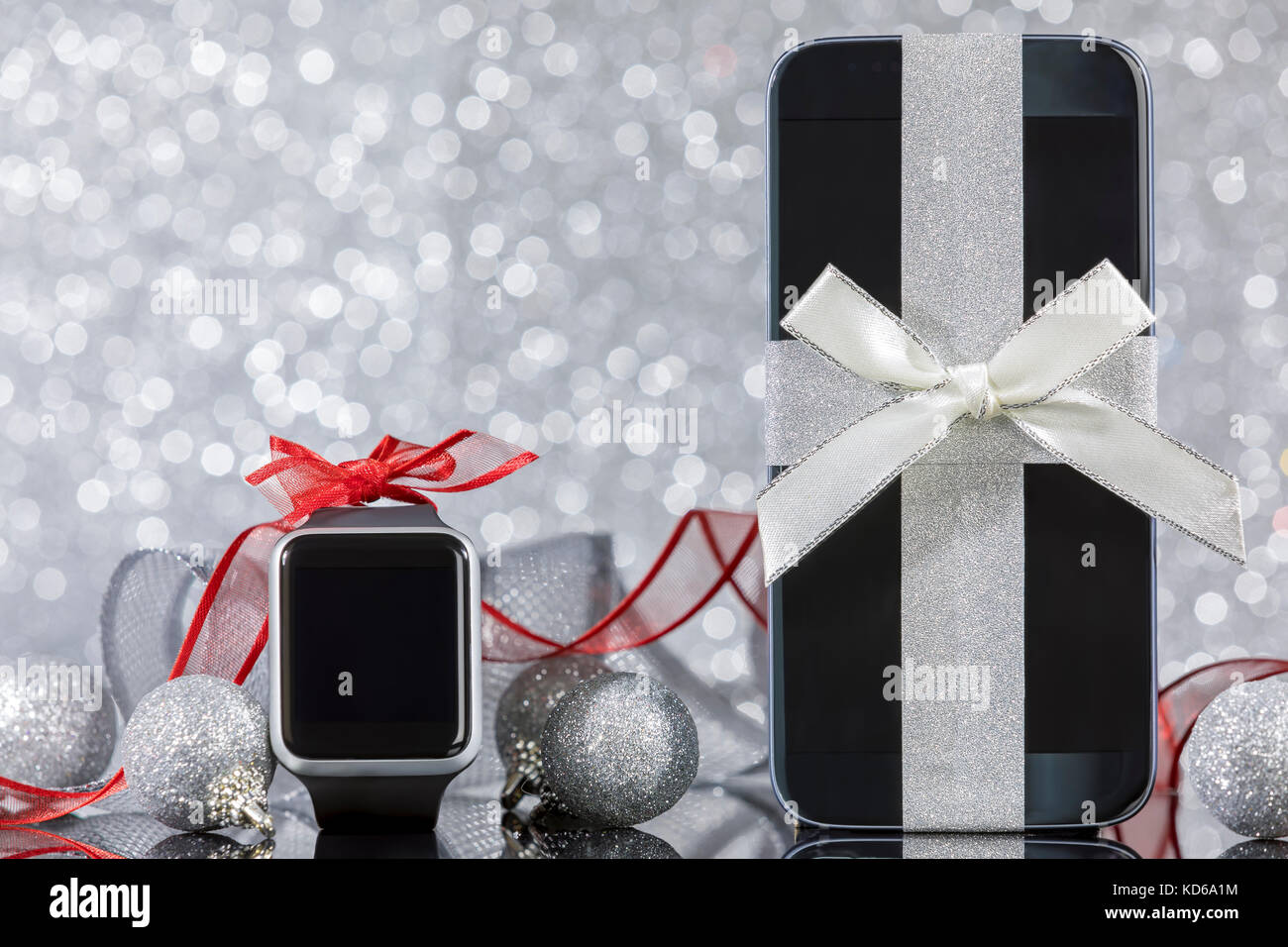 Smartphone et smartwatch et décorations pour arbre de Noël sur la table en verre noir. Se concentrer sur smartphone. Banque D'Images