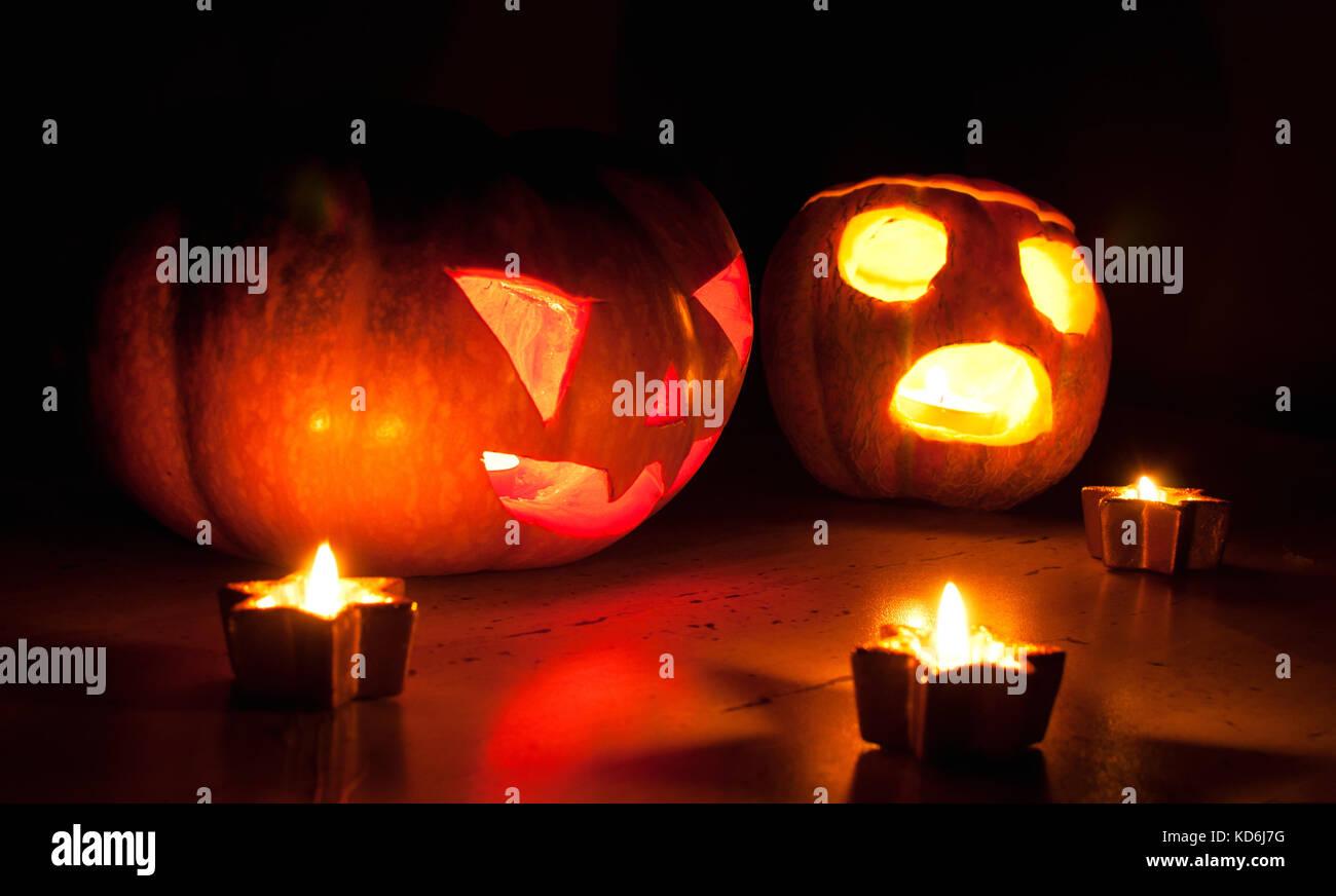 Scary Halloween Pumpkin et melon jack-o-lanternes sur fond noir allumé des petits et star des bougies. selective focus, bokeh. Banque D'Images