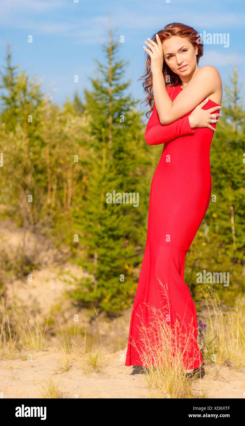 Dame dans une robe rouge dans la forêt d'été Banque D'Images