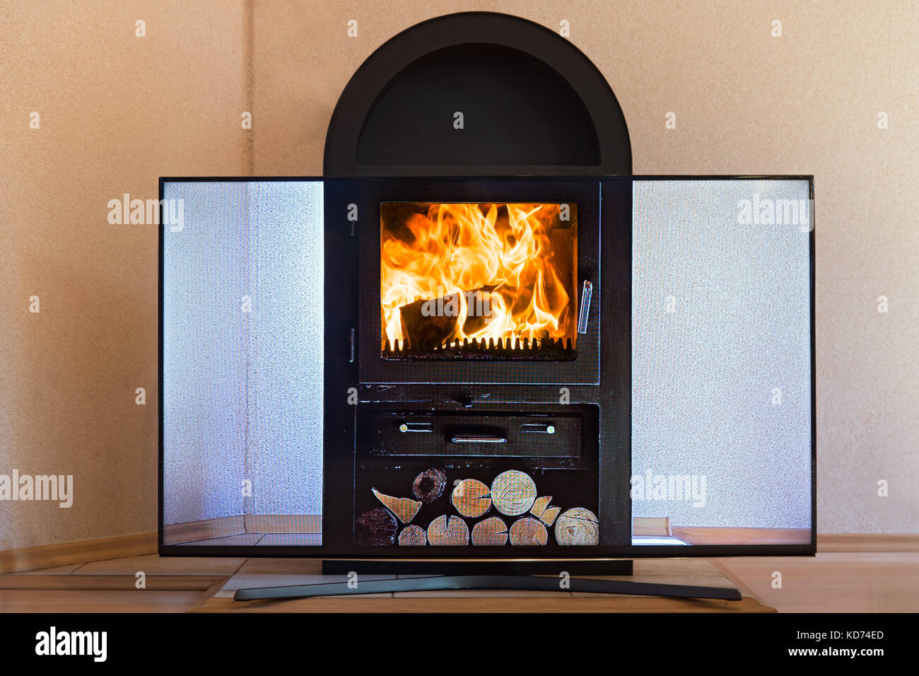 La télévision avec la vidéo de la cuisinière se tient devant le poêle dans l'appartement. l'écran de télévision imite le feu dans la cheminée poêle. Banque D'Images