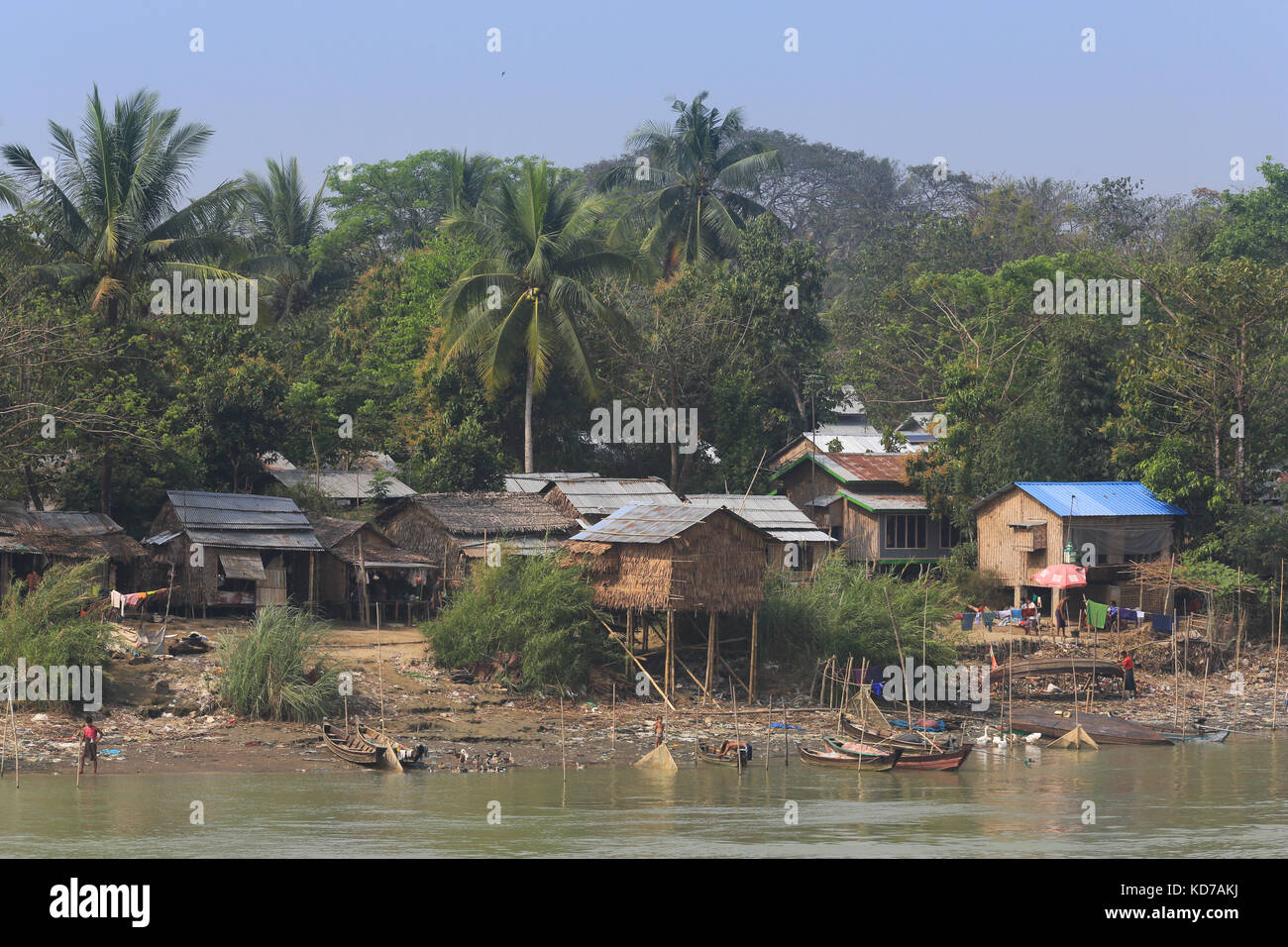 Un homme travaille sur son bateau chaviré sur les rives de la rivière Irrawaddy à maubin au Myanmar (Birmanie). Banque D'Images