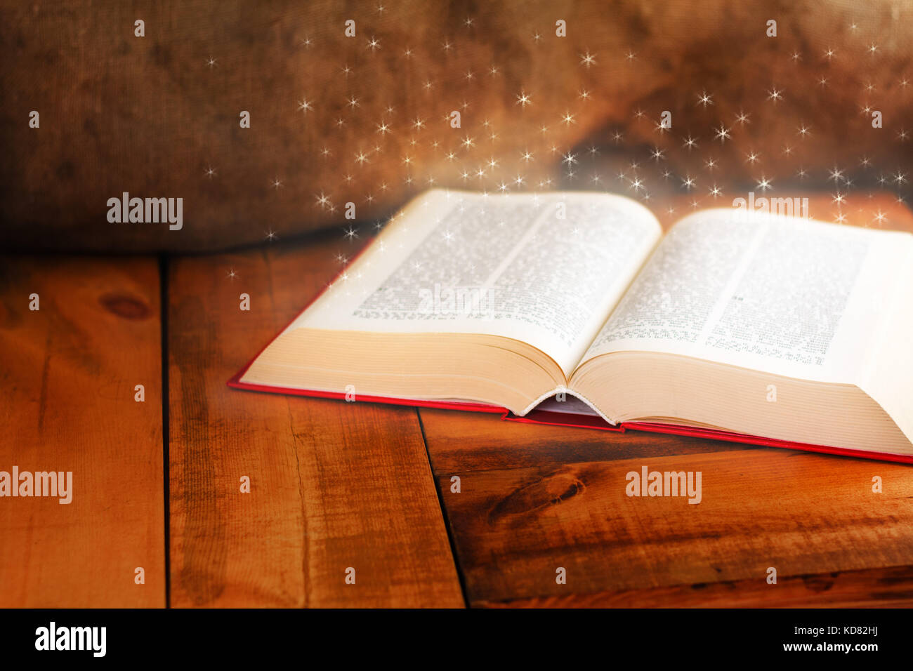 Vieux livre ouvert avec magic light on wooden table Banque D'Images