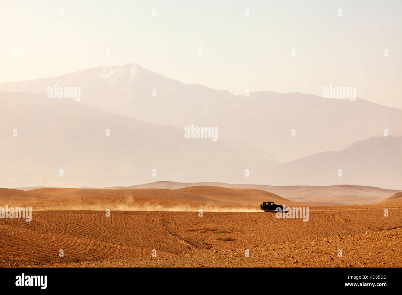 Conduite du véhicule hors route à travers le désert agafay, Maroc, atlas, disparaissant dans la brume Banque D'Images