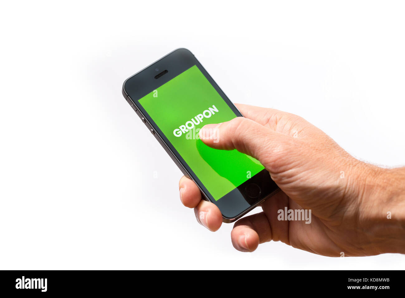 Un homme à l'aide de l'app Groupon sur un téléphone mobile Banque D'Images