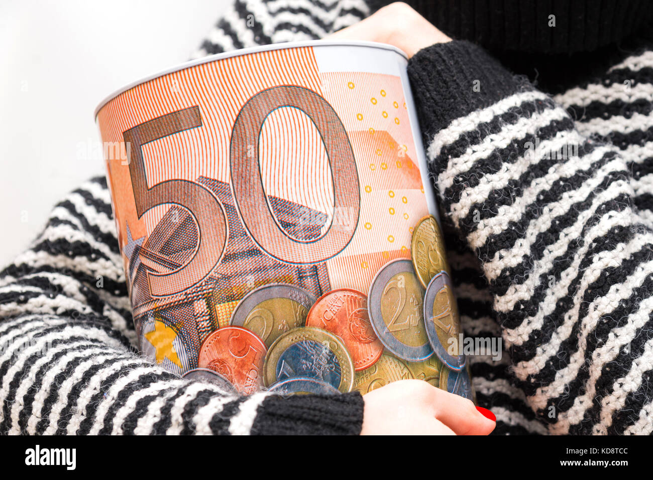 Une femme est titulaire d'une tirelire dans ses mains et un fond blanc Banque D'Images