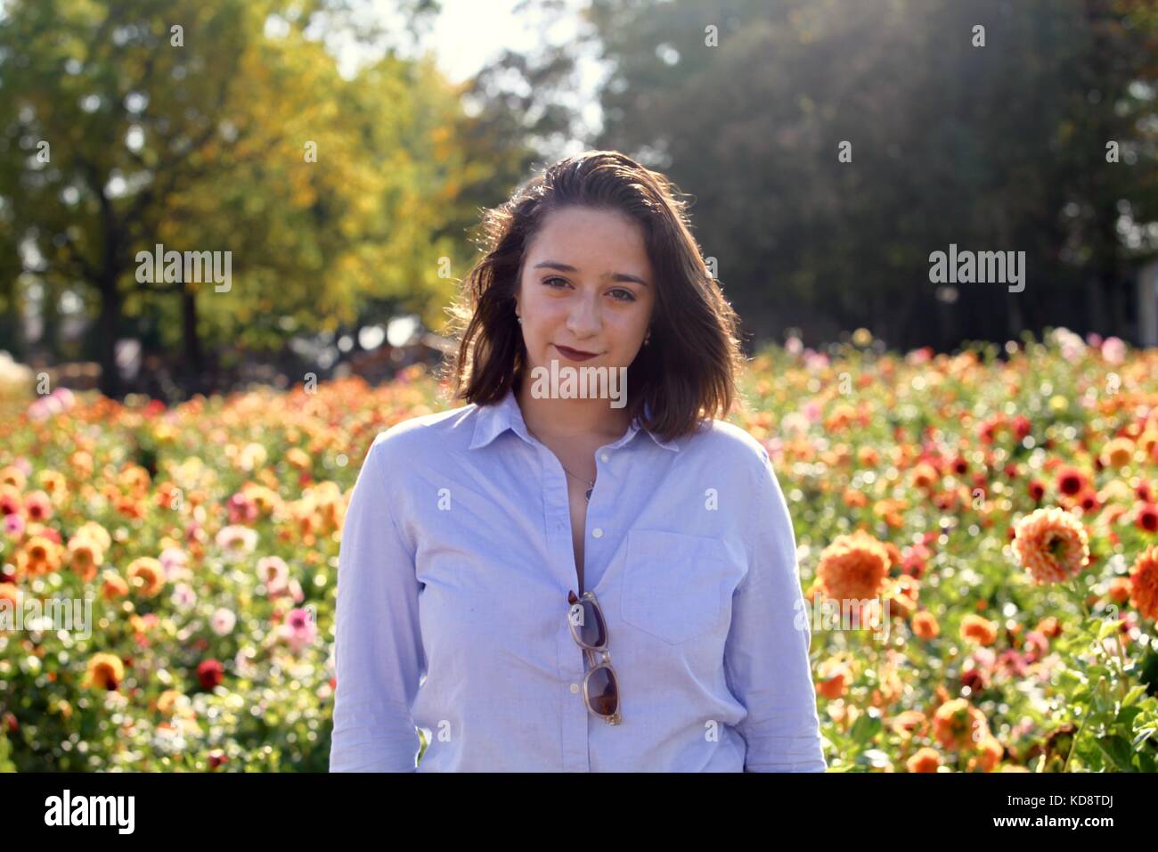 Portrait of a young woman model posing pour la caméra dans un champ de fleurs Banque D'Images