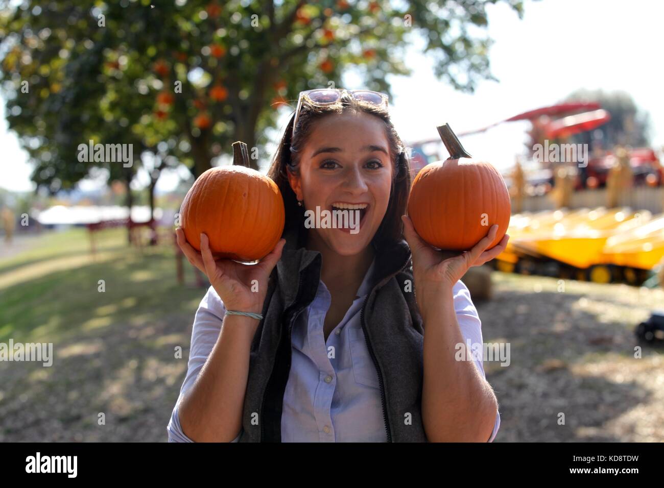 La femme tenant deux petites citrouilles à la ferme Banque D'Images