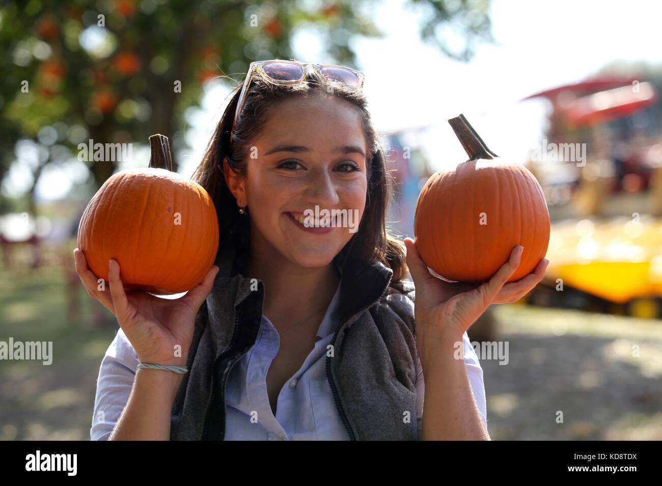 La femme tenant deux petites citrouilles à la ferme Banque D'Images