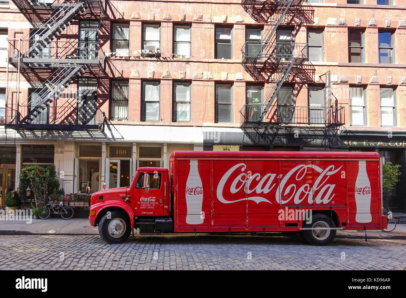 Coca Cola américain des camions de livraison en face de bâtiment en briques typique de New York avec le feu s'échappe, Manhattan, États-Unis. Banque D'Images