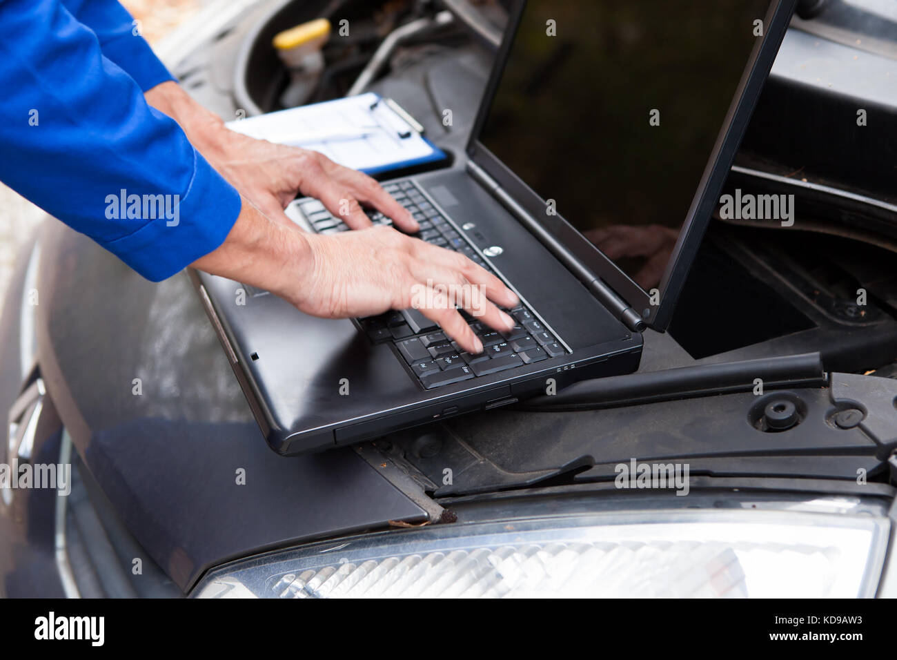 Close-up d'un mécanicien de voiture à l'aide d'ordinateur portable pour voiture Réparation Banque D'Images