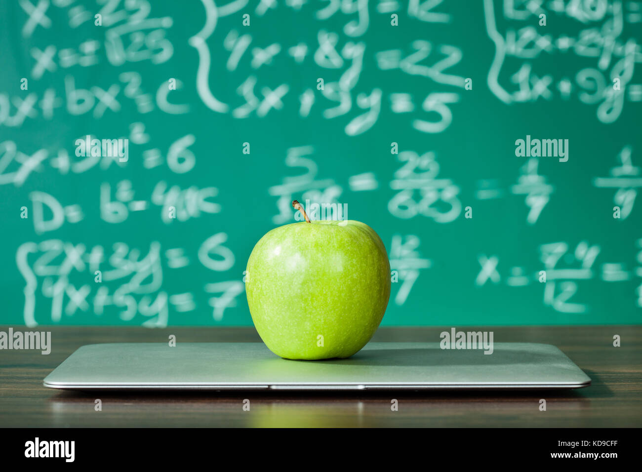 Ordinateur portable apple et sur le bureau in front of blackboard Banque D'Images