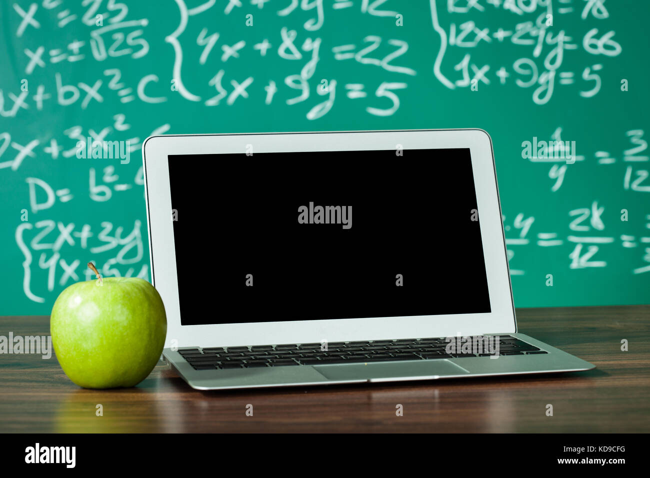 Ordinateur portable apple et sur le bureau in front of blackboard Banque D'Images