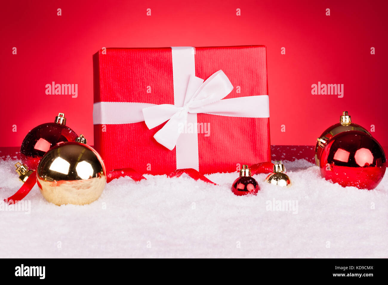 Boules de Noël avec cadeaux sur fond rouge Banque D'Images