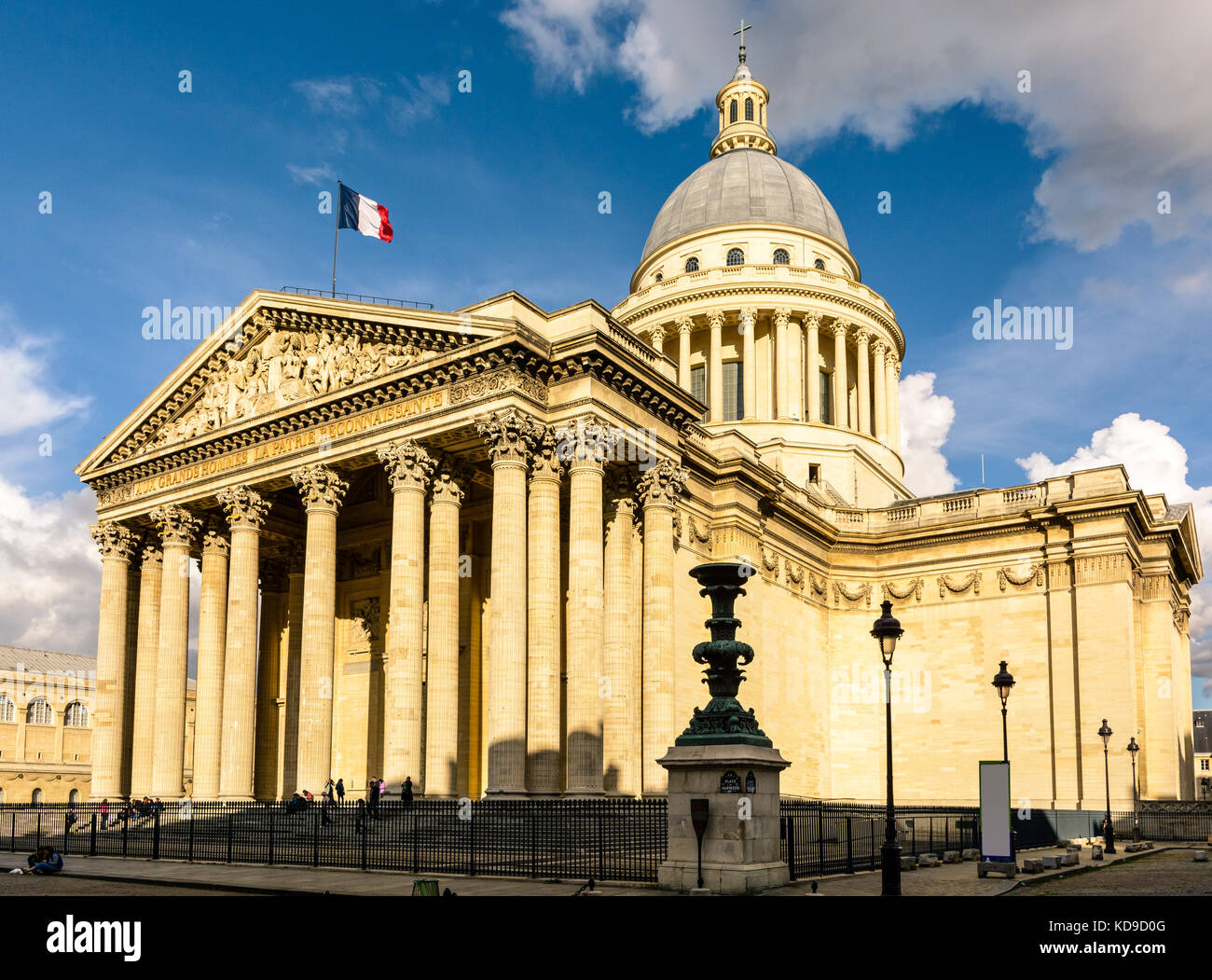 Vue de trois quarts du Panthéon à Paris au coucher du soleil avec le drapeau français volant dans le vent. Banque D'Images