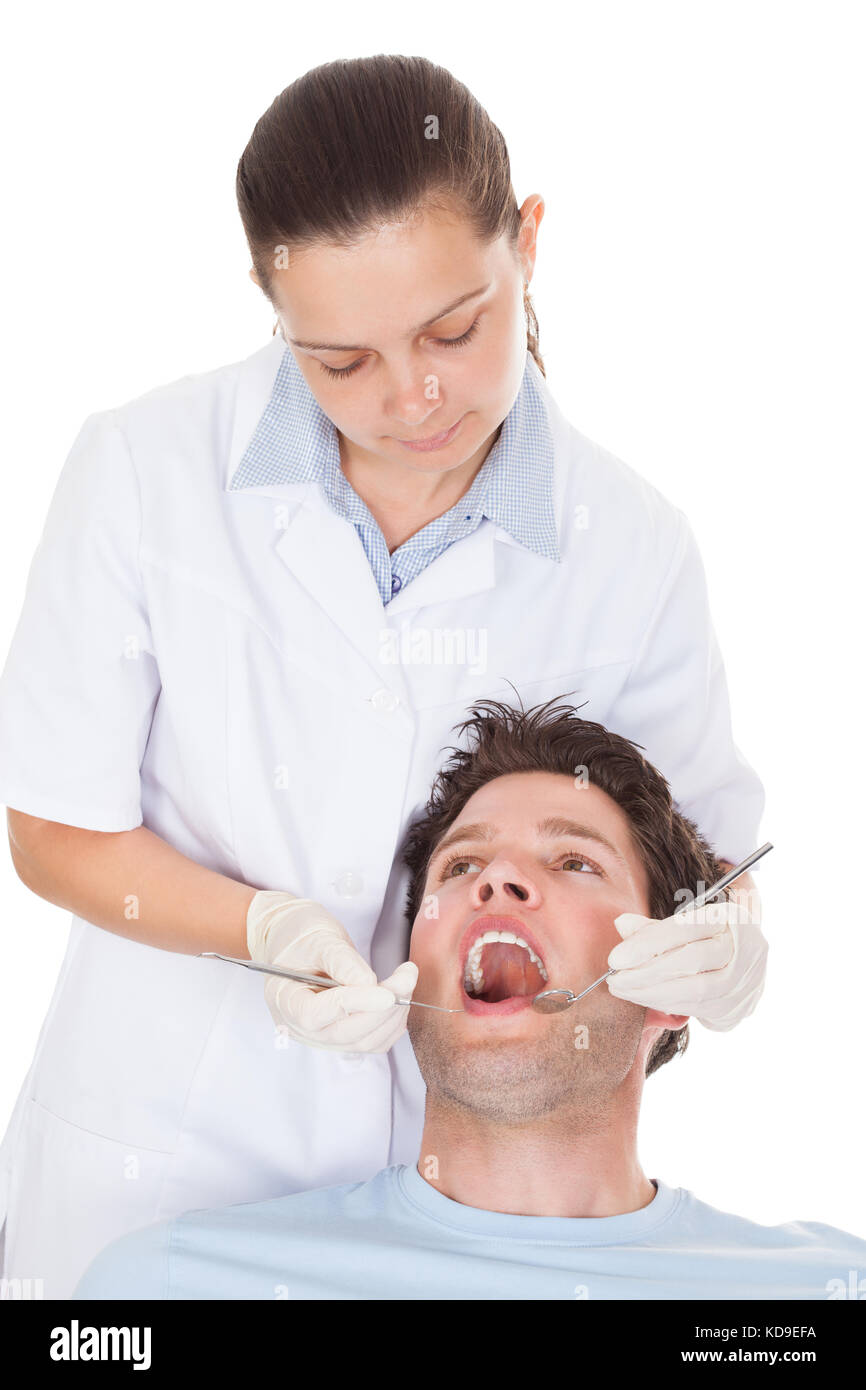 Close-up of a female dentist examining patient's dents sur fond blanc Banque D'Images