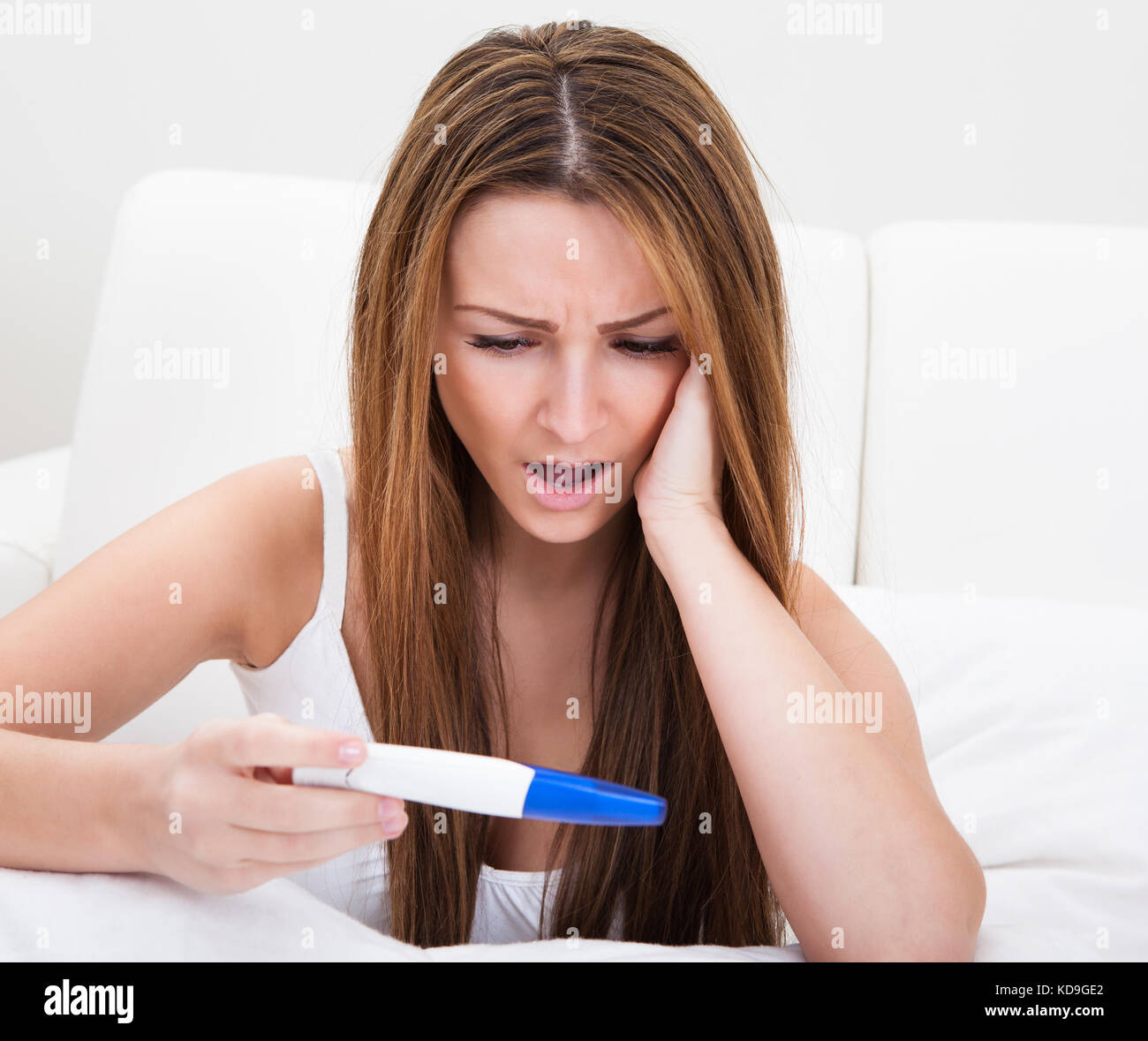 Jeune femme inquiète contrôle test de grossesse à la maison Banque D'Images